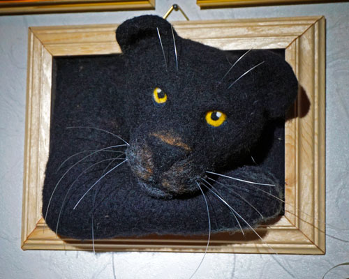 Foto einer Filzfigur: Panther schaut aus dem Bilderrahmen heraus