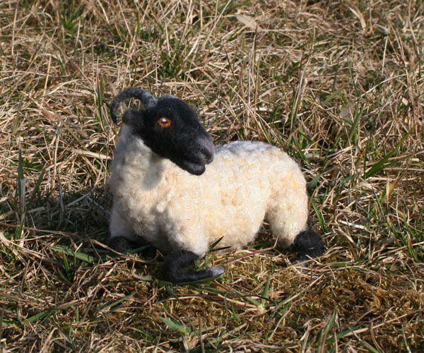 Foto einer Filzfigur: Schaf liegt im Gras